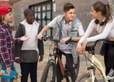 Group of preteens sitting on their bikes talking