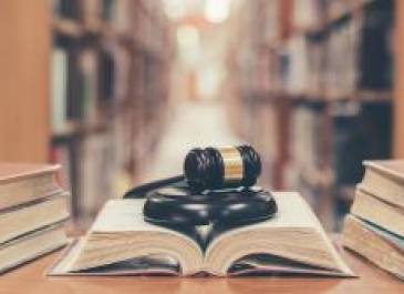 Library background with an open book and gavel on a desk.