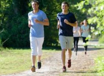 Teenage boys jogging down a dirt path.