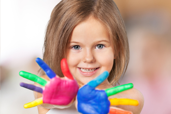Smiling blonde little girl with painted hands