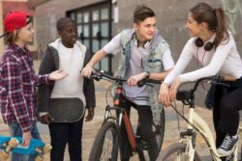 Group of preteens sitting on their bikes talking